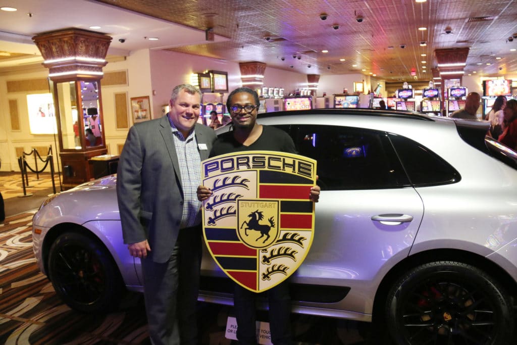 Ammon B., a clinical researcher from Memphis, is pictured just moments after learning he won a Porsche Macan with his new car and Caesars Mid-South Regional President, R. Scott Barber at Horseshoe Tunica.